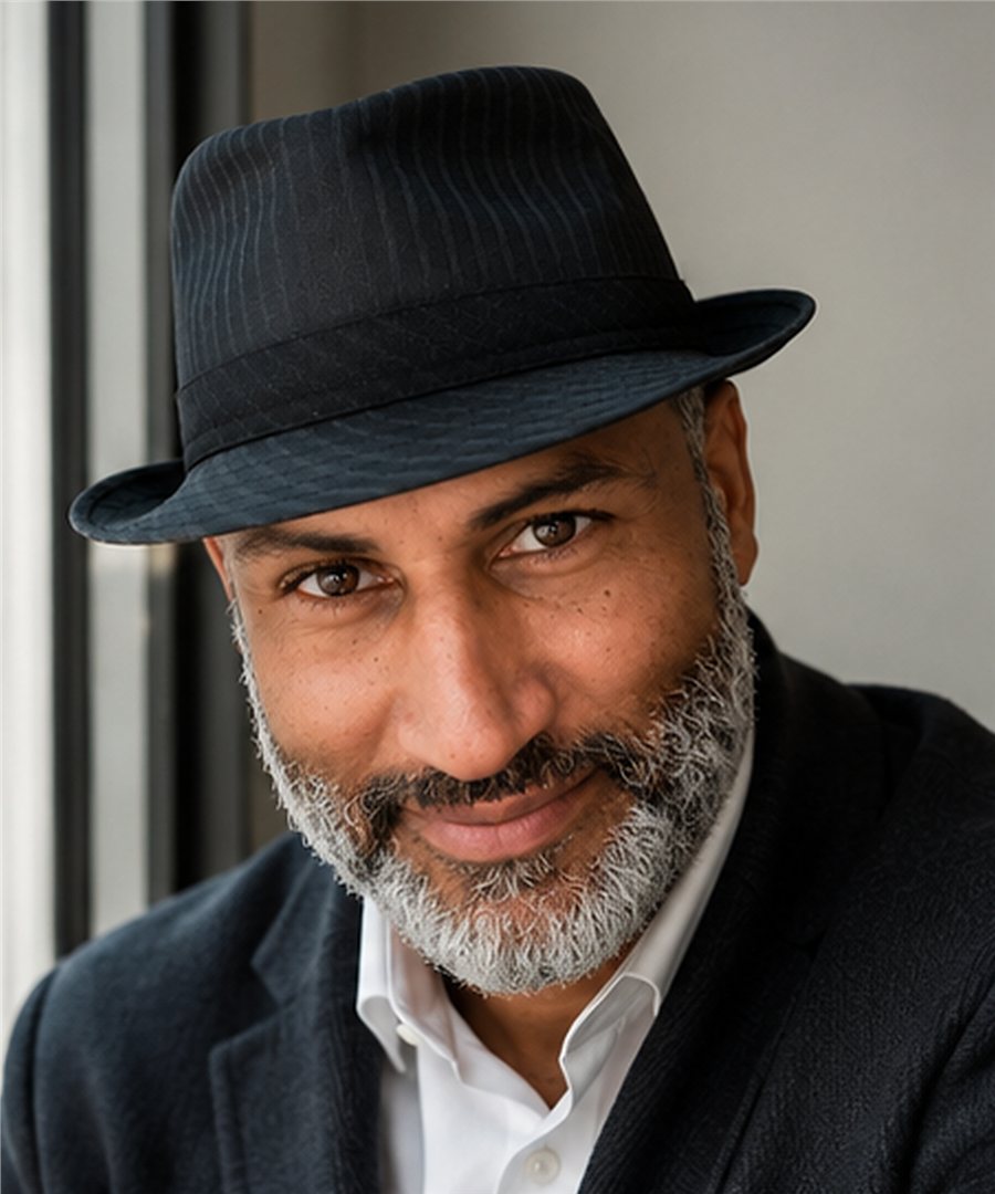 Author Nathan E. Brooks wearing a black hat and smiling warmly